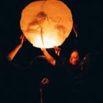 girl lifting lantern to the sky