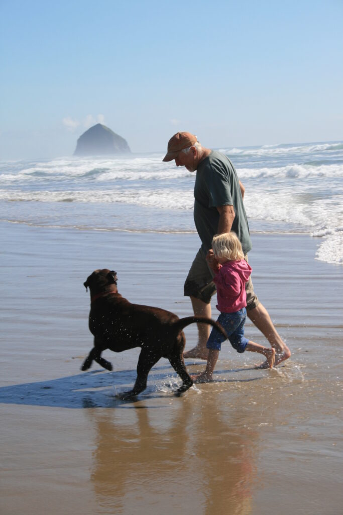 grandpa running on the beach with his grandchildren