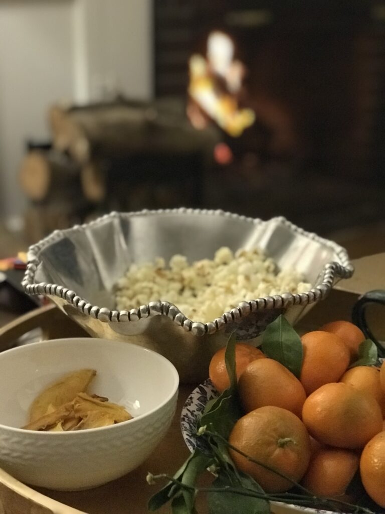 bowl with popcorn, and mandarines by the fire