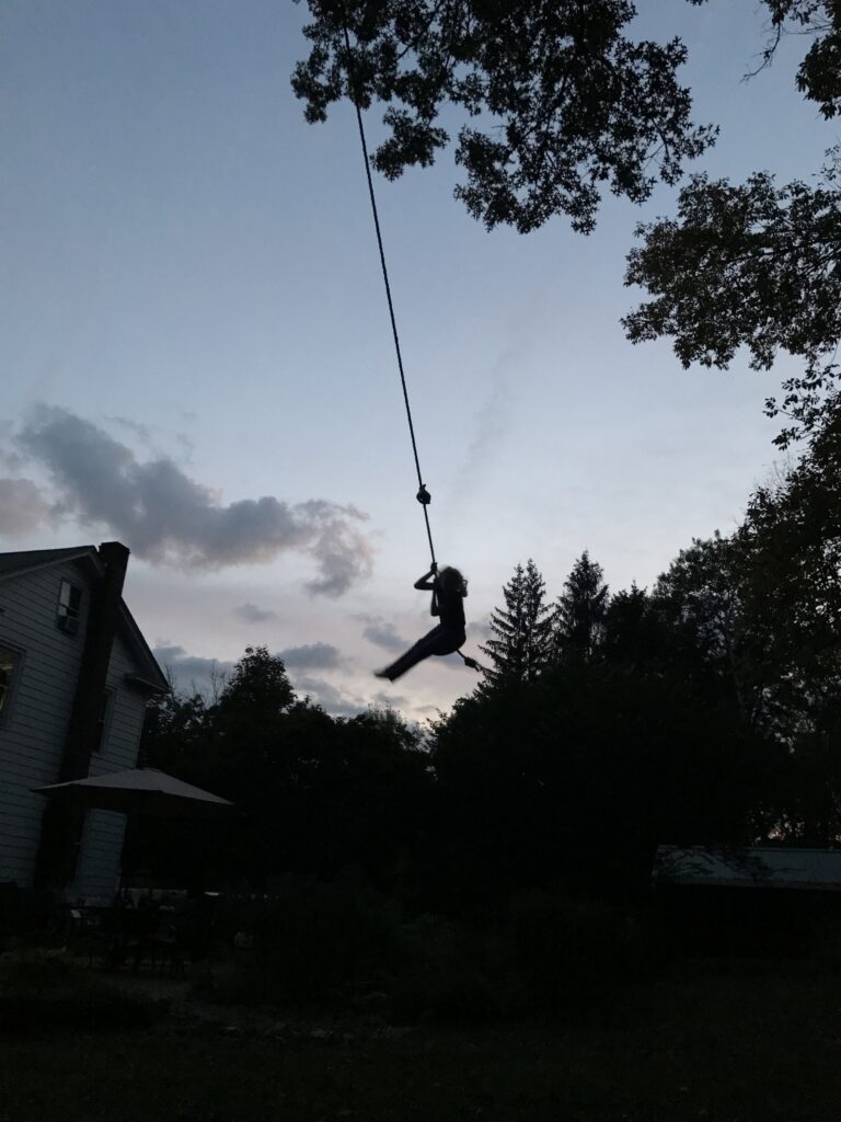 child on a swing at sunset