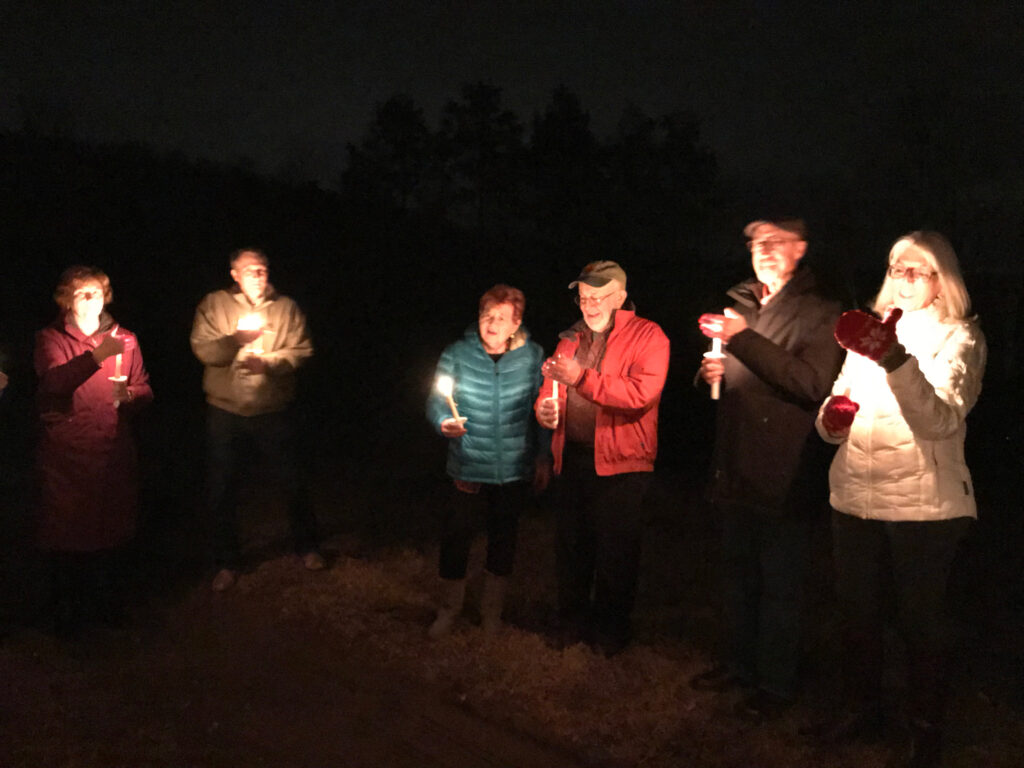 carolers singing in the candlelight