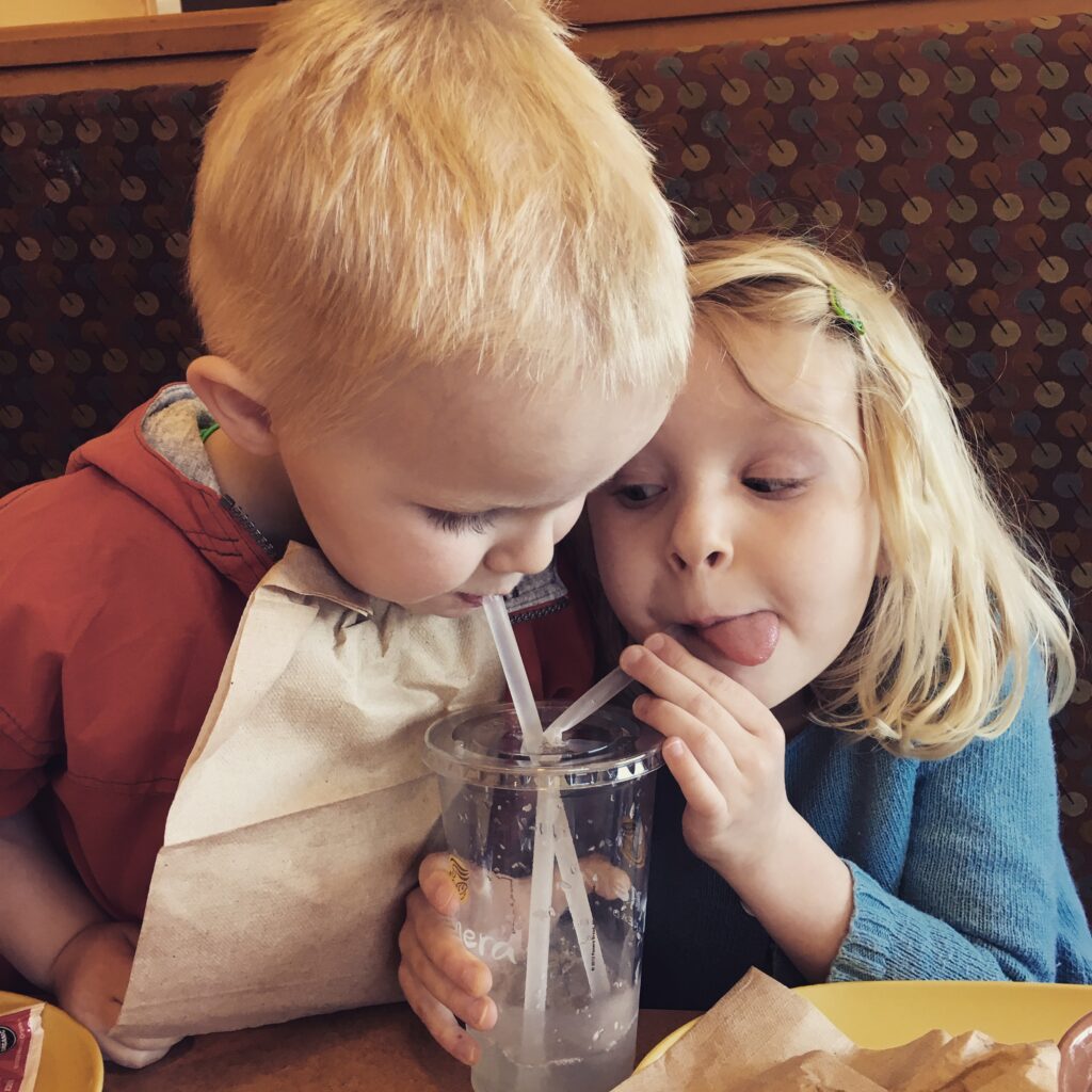 two children sipping from straws