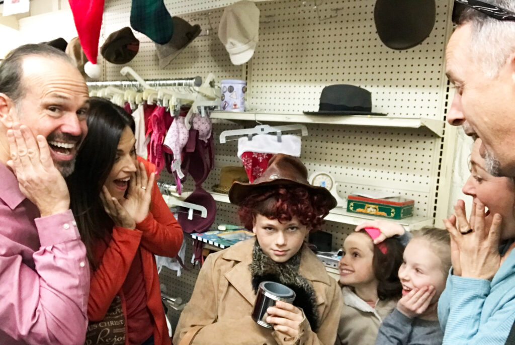 group of people staring at a boy in a hat at a second hand store