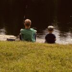 two boys fishing by the pond