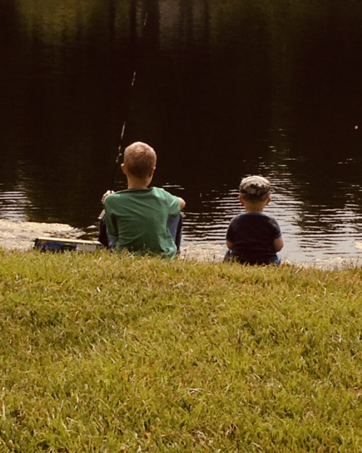 two boys fishing by the pond