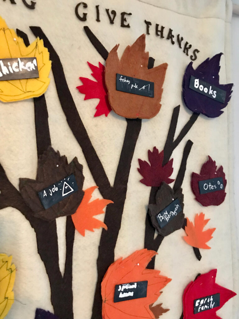 closeup of a felted tree with autumn leaves with notes on them