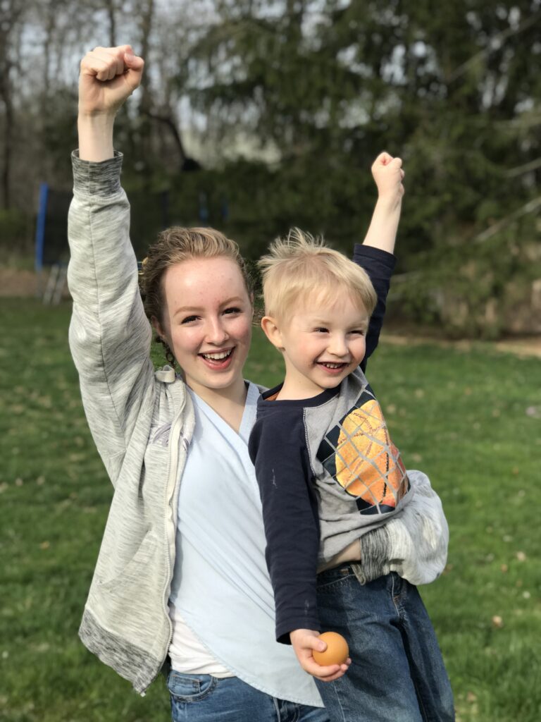 girl and boy celebrating a victory with hands in the air