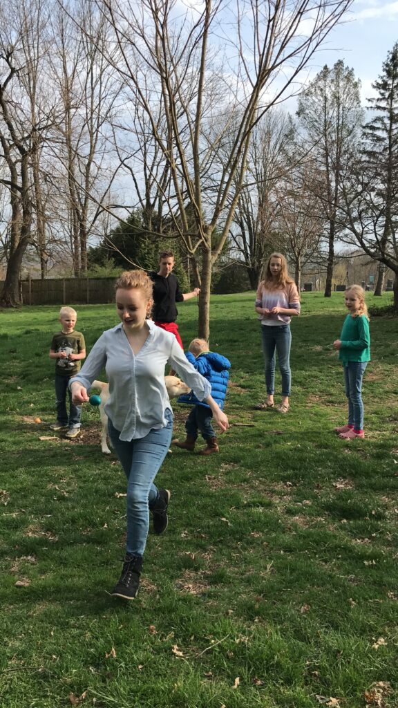 girl running with an egg on a spoon during Easter relay race