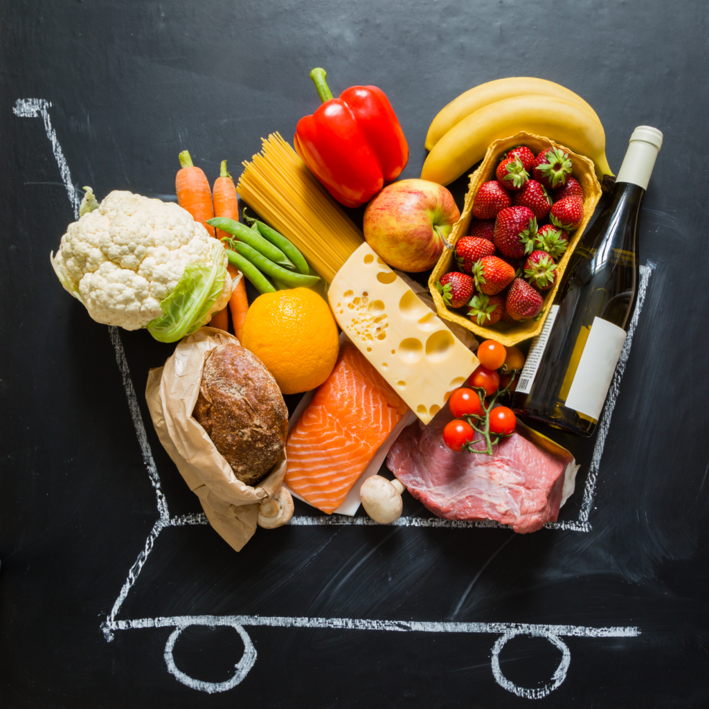 a grocery cart filled with real food on a chalkboard