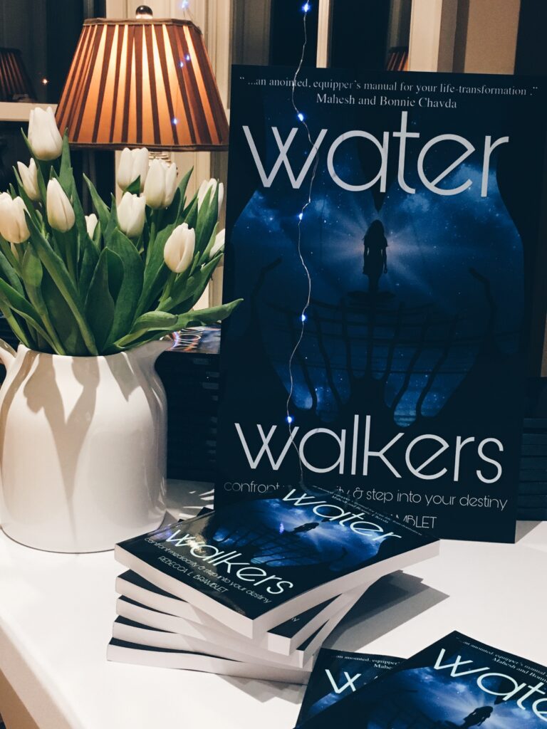 picture of the book water walkers with a pitcher of white tulips