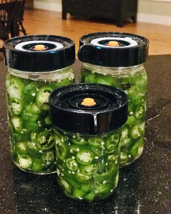 3 jars of jalapeños with fermenting lids