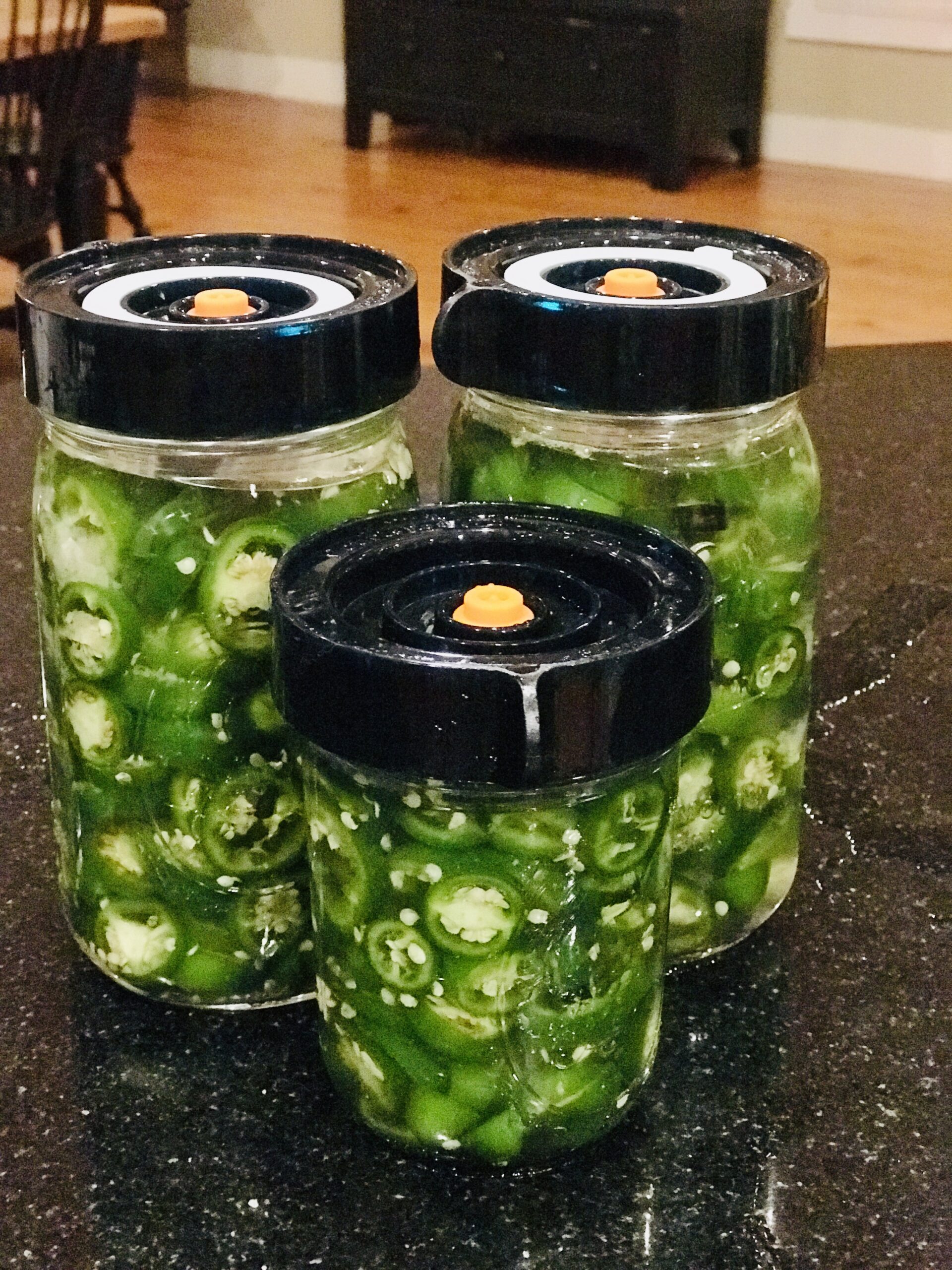 3 jars of jalapeños with fermenting lids