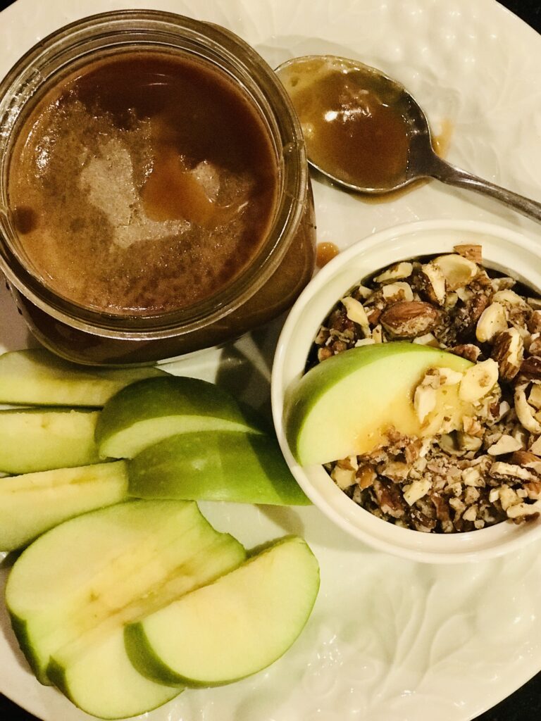 a plate of apples, nuts, and caramel sauce