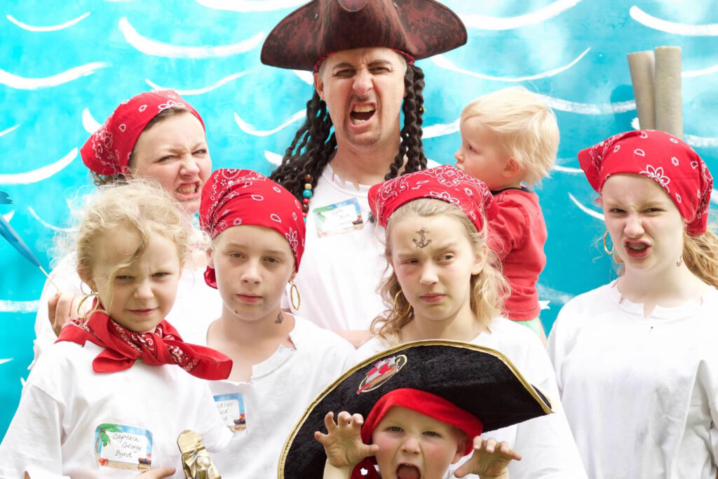 a family dressed as pirates in front of a blue water background