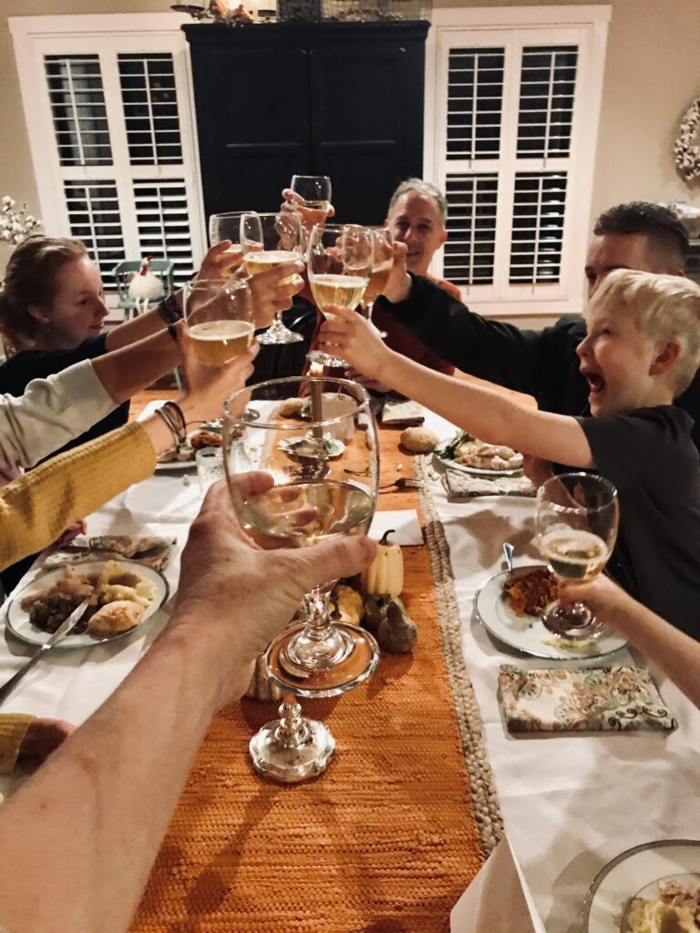 a family at the table giving a toast with their glasses raised