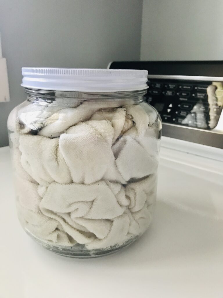 a jar full of cloths on top of a washing machine
