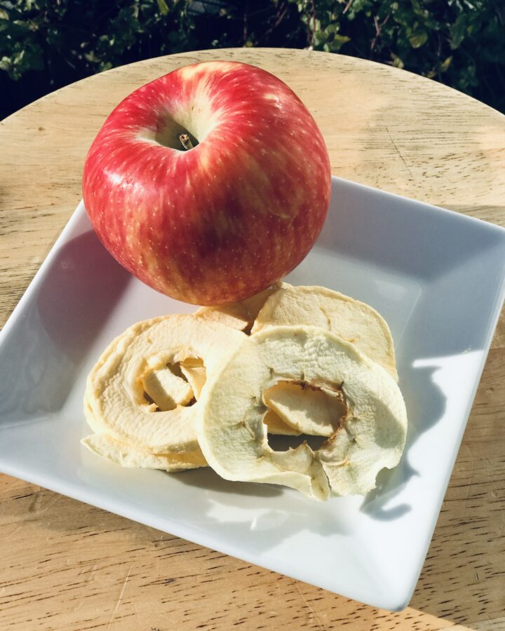 an apple with a plate of sweet and sour apple rings