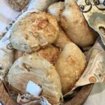 dinner rolls in a wooden basket with cloth