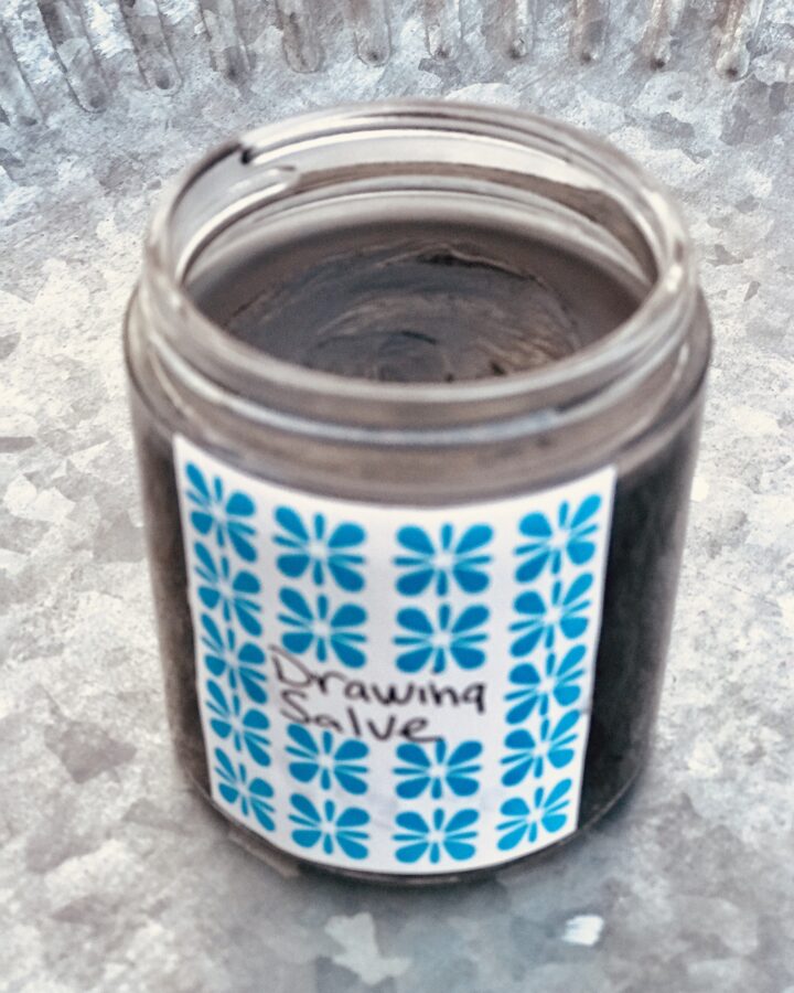 a jar of drawing salve on a pewter tray