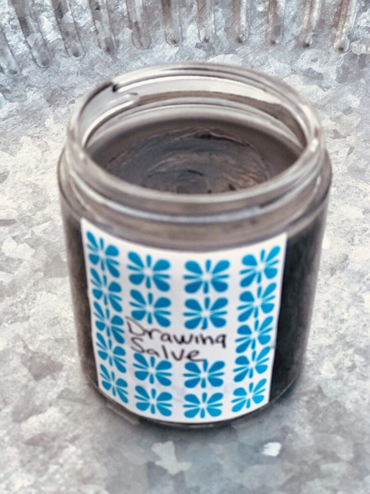 a jar of drawing salve on a pewter tray