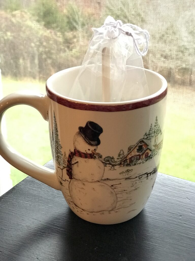 hot chocolate on a stick gift bag inside a snowman mug