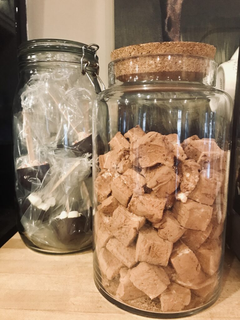 a jar of marshmallows and a jar of hot chocolate on a stick