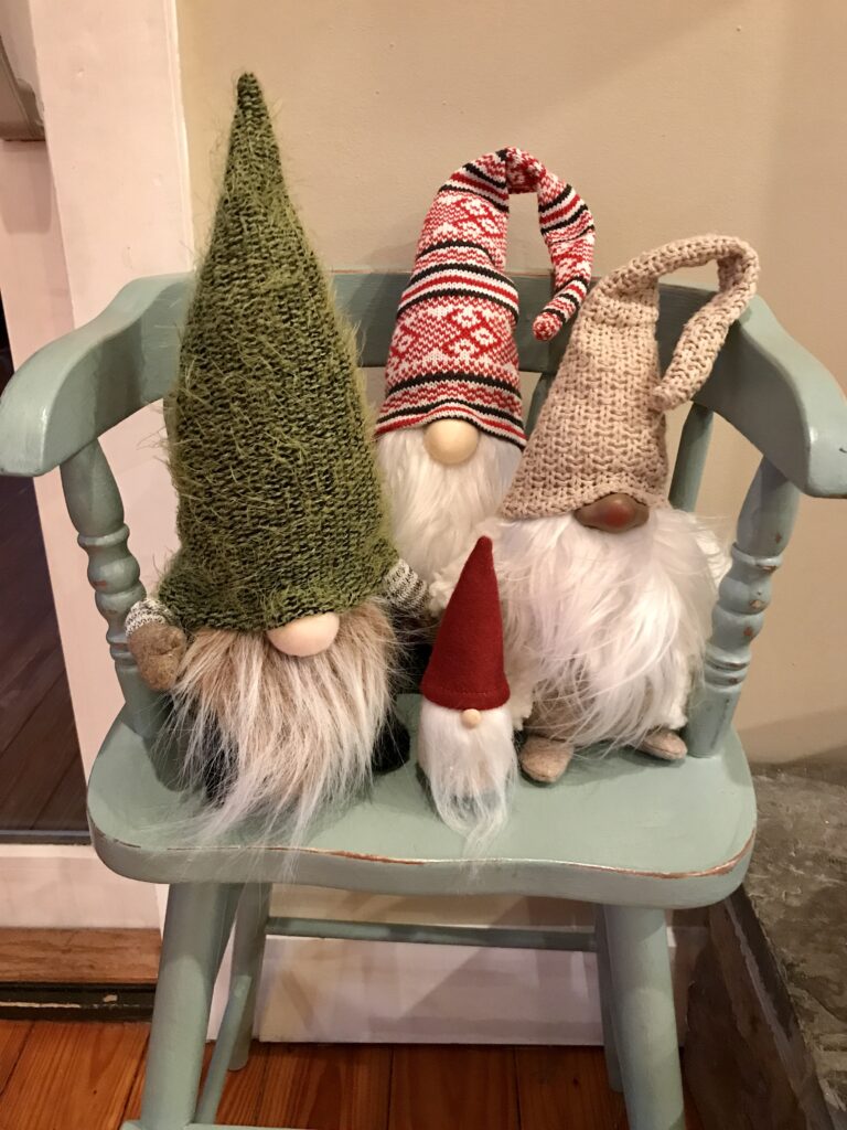 a chair with 4 stuffed gnomes