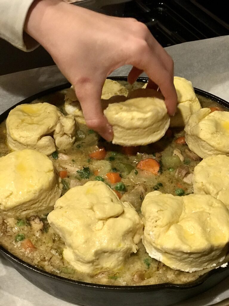 placing the biscuits on skillet chicken and biscuits