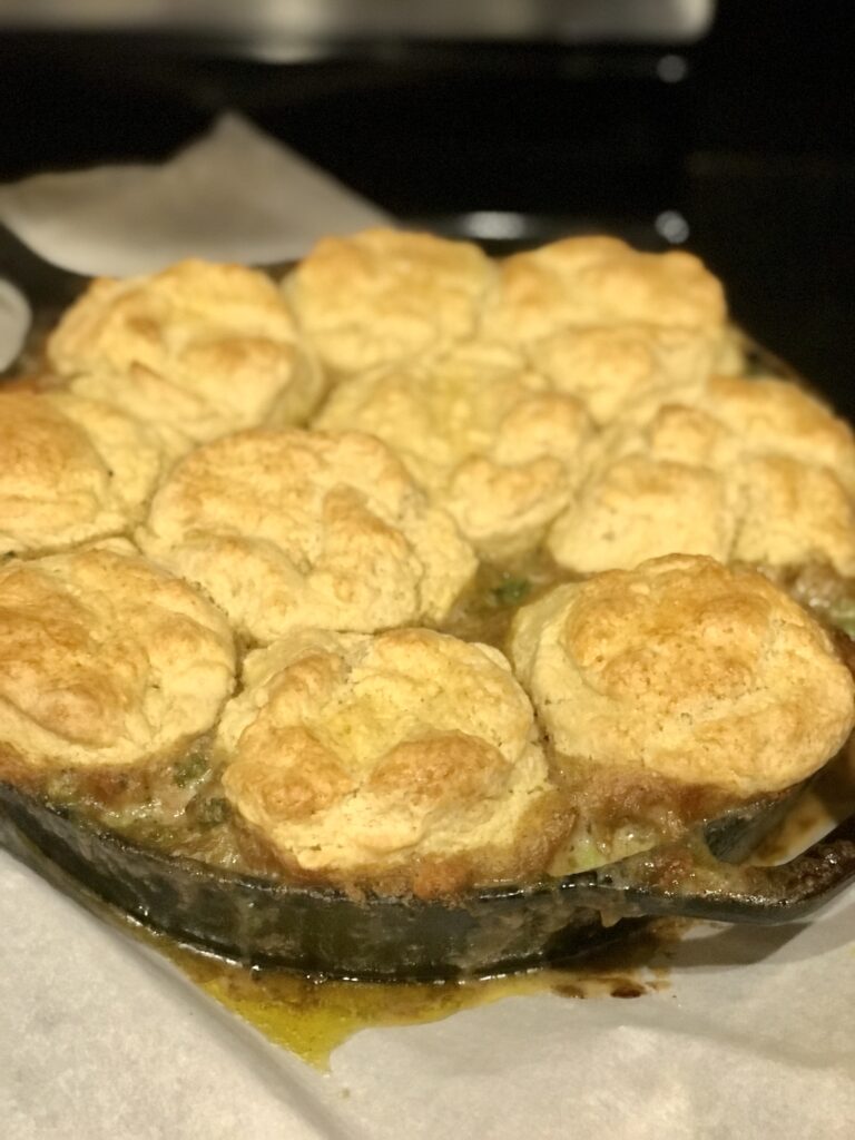 a cast iron skillet of chicken and biscuits