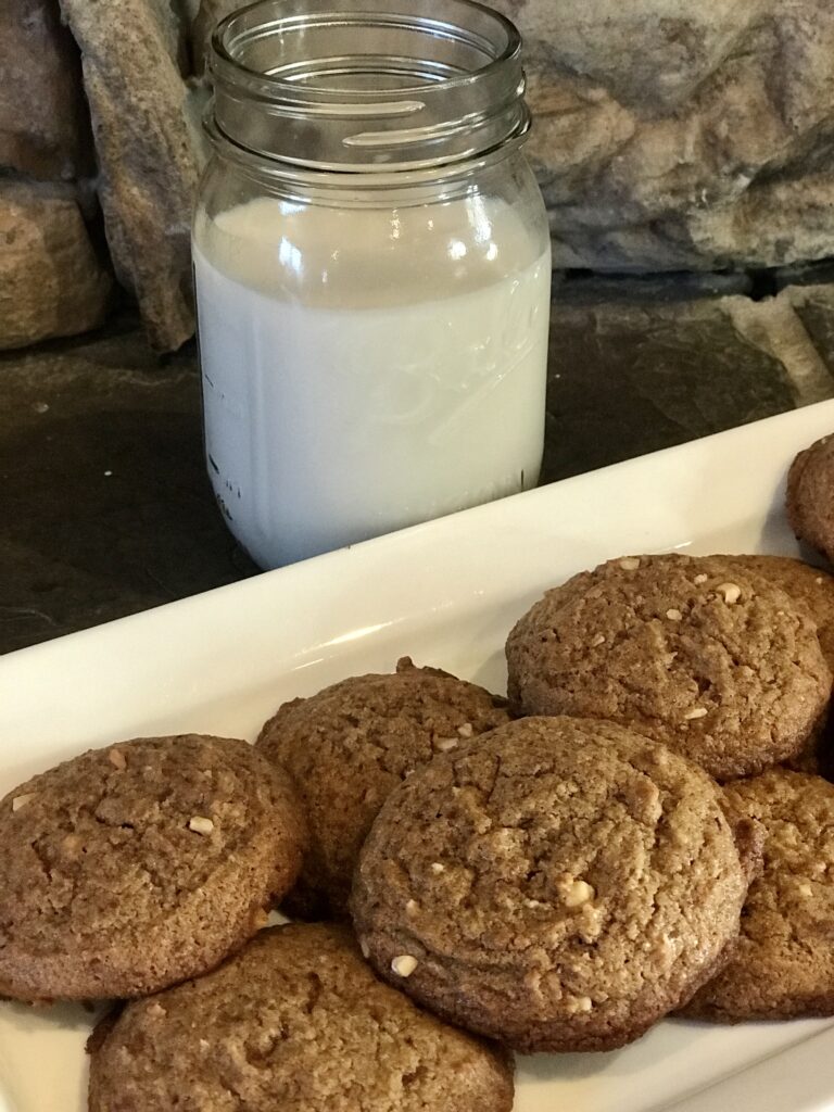 a close up image of peanut butter cookies and milk in the background