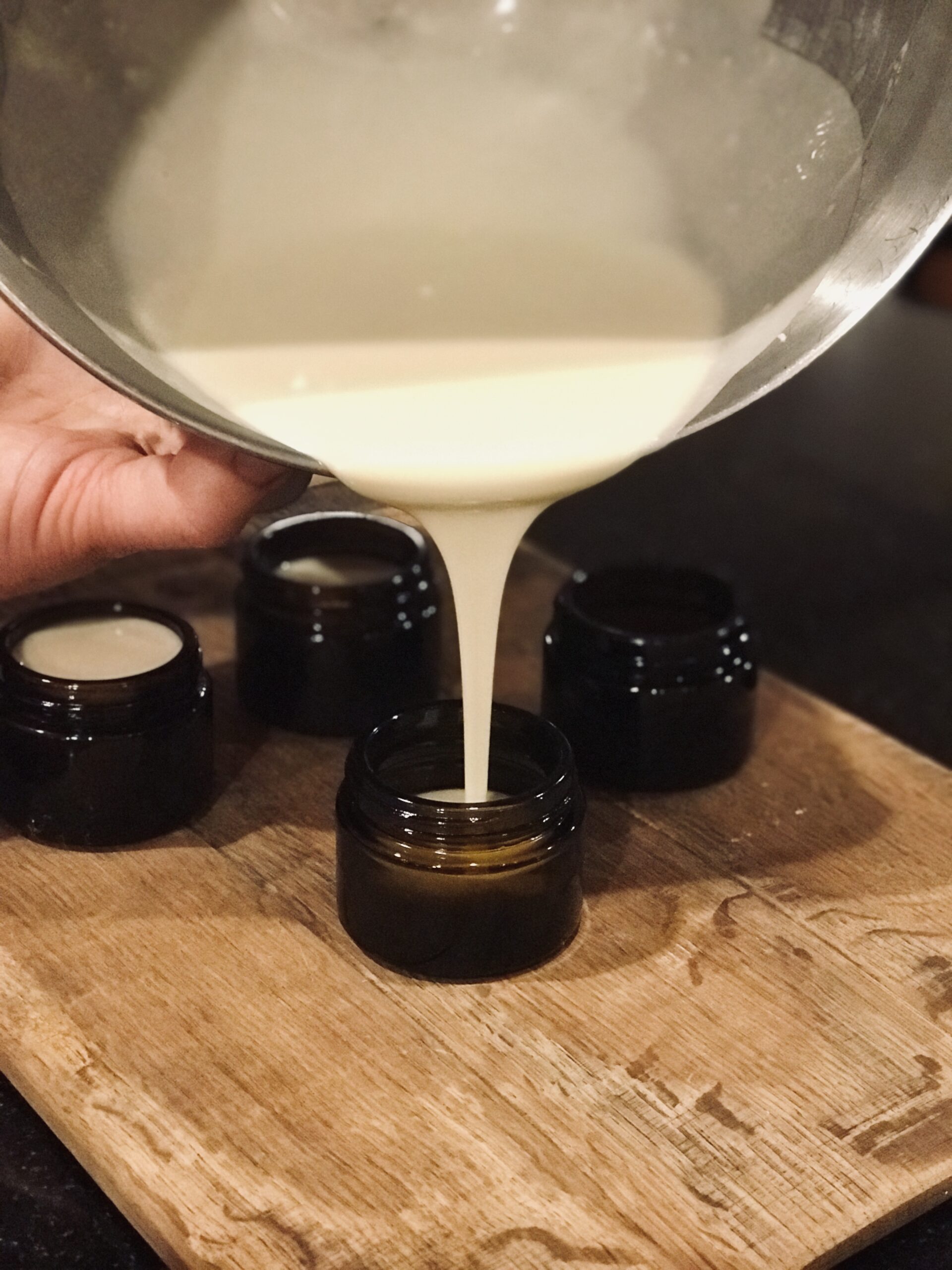 pouring the winter tallow & honey butter cream into containers