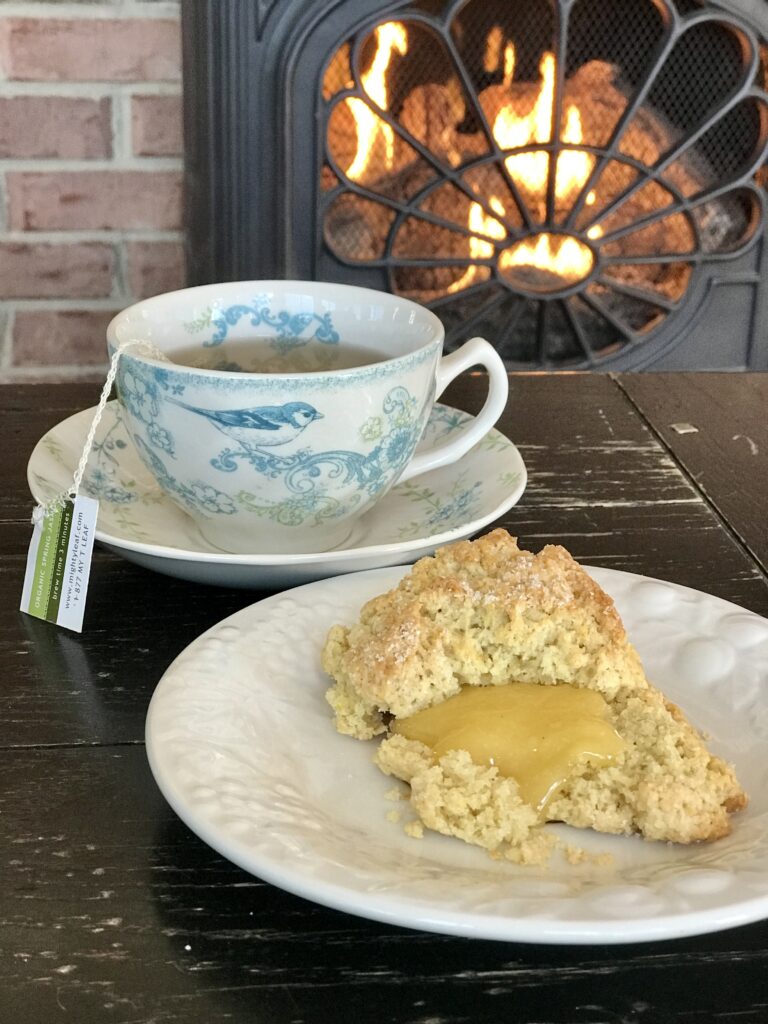 a scone with lemon curd and tea by the fire