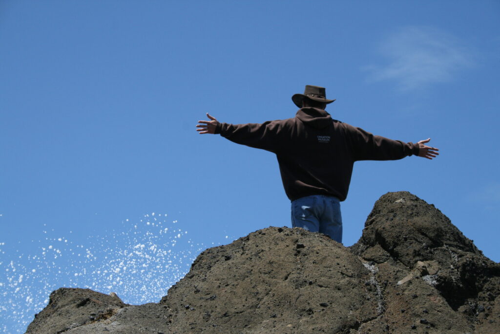 a man on a rock with arms wide open to the God of the covenant of Grace