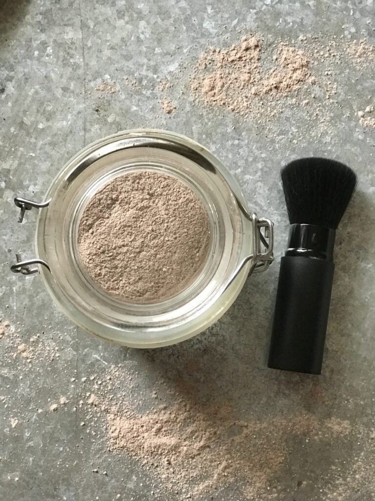face powder and a brush on a tin tray