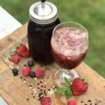 summer sunshine shrub on a board with berries and herbs