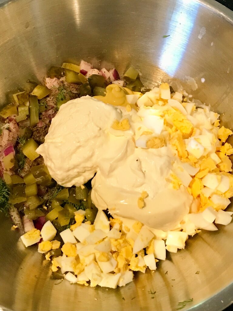 a bowl of ingredients for picnic potato salad