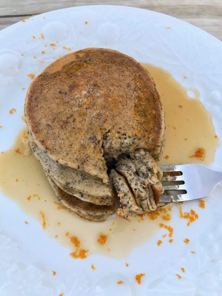 plate of buckwheat pancakes with a bite on a fork