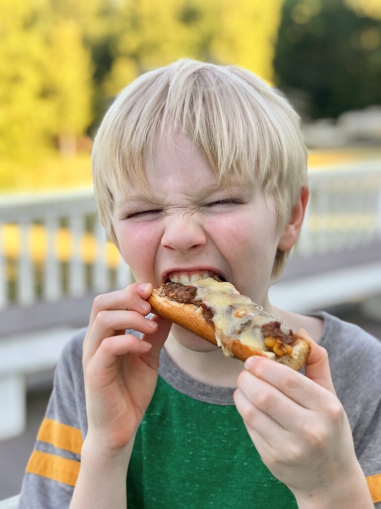 Nathan biting a hamburger-by-the-yard