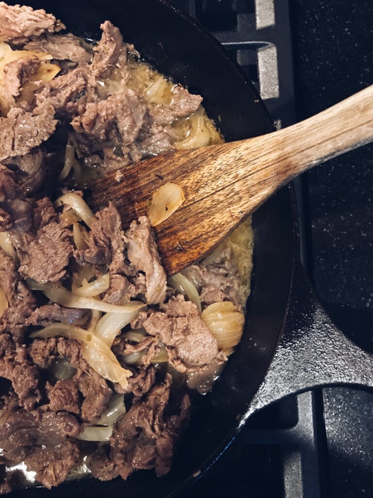 cast iron pan with meat and onions
