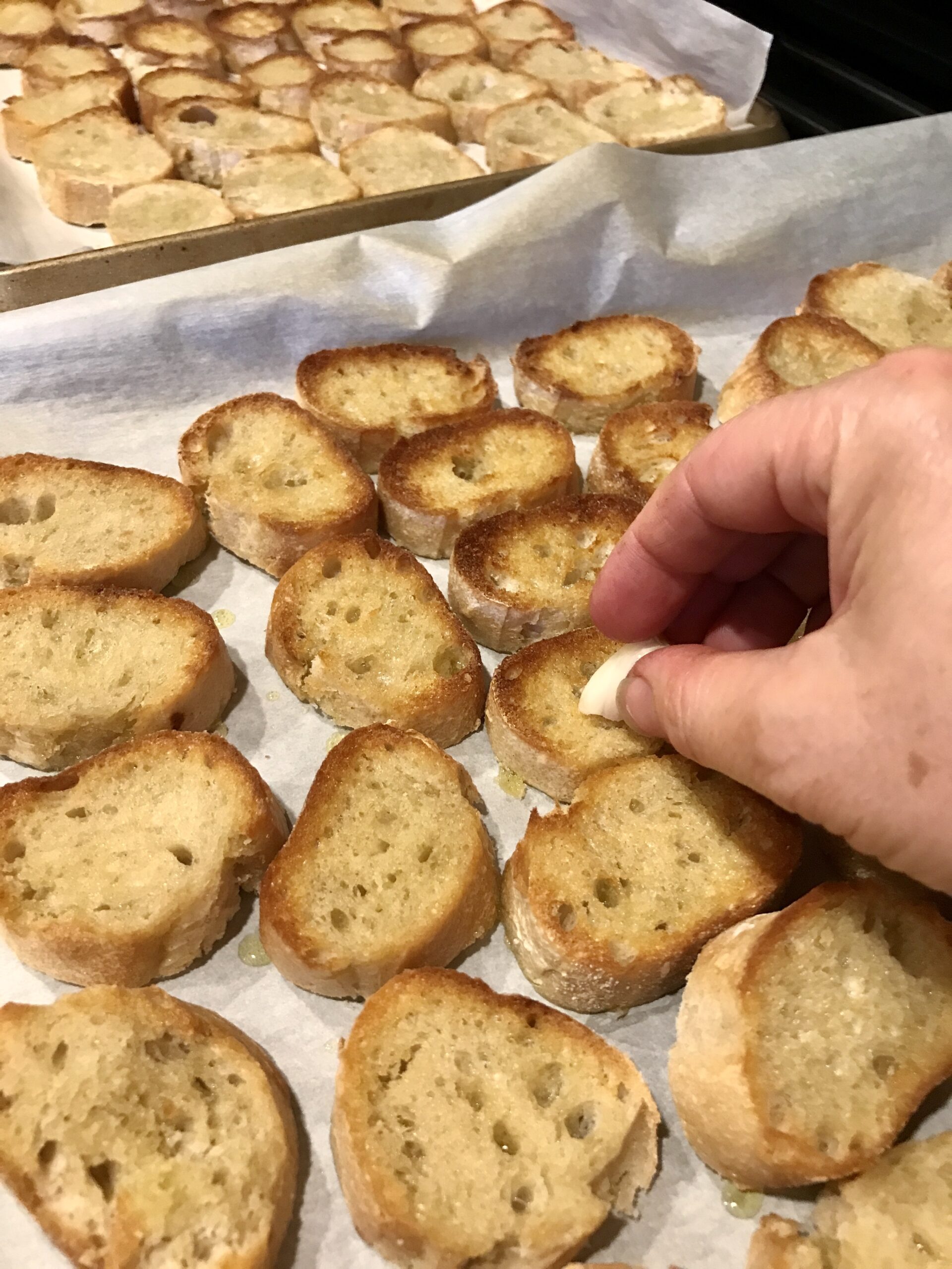 rubbing bruschetta toast with garlic