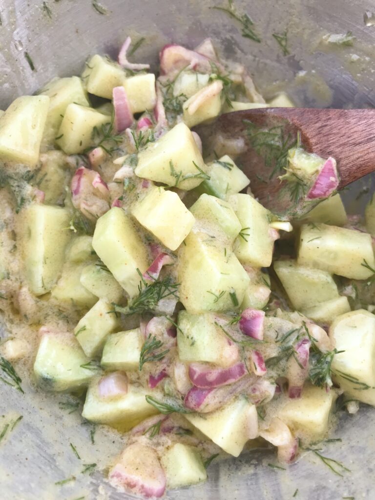 cucumber mustard sauce in a bowl with wooden spoon 
