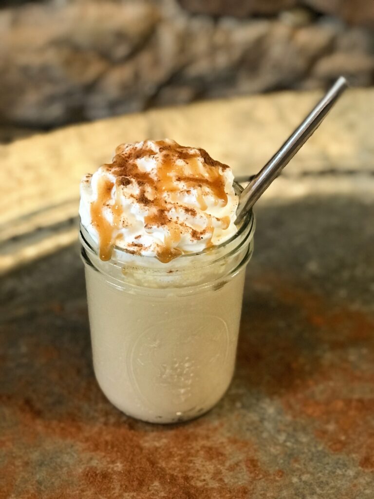 a Caramel Frappuccino on a silver tray with silver straw
