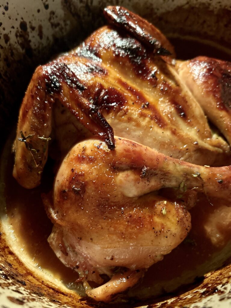 a side view of maple glazed chicken in a dutch oven