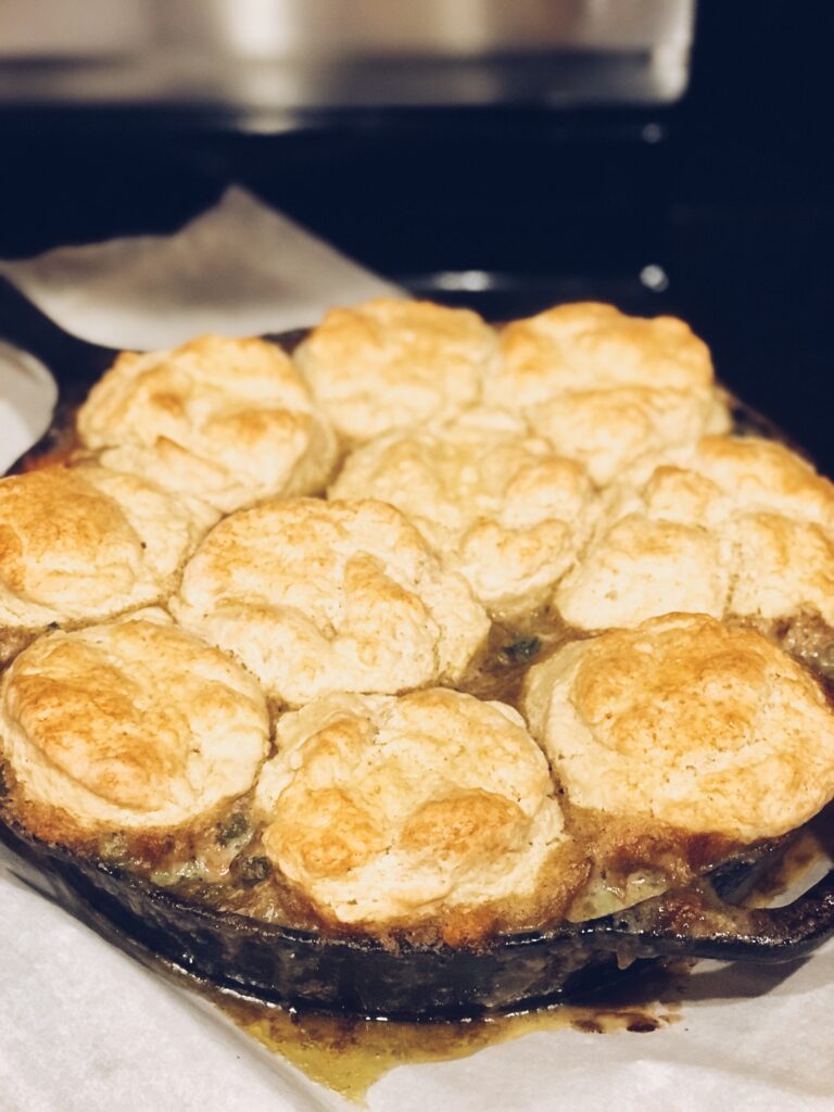 a cast iron skillet of baked chicken & biscuits