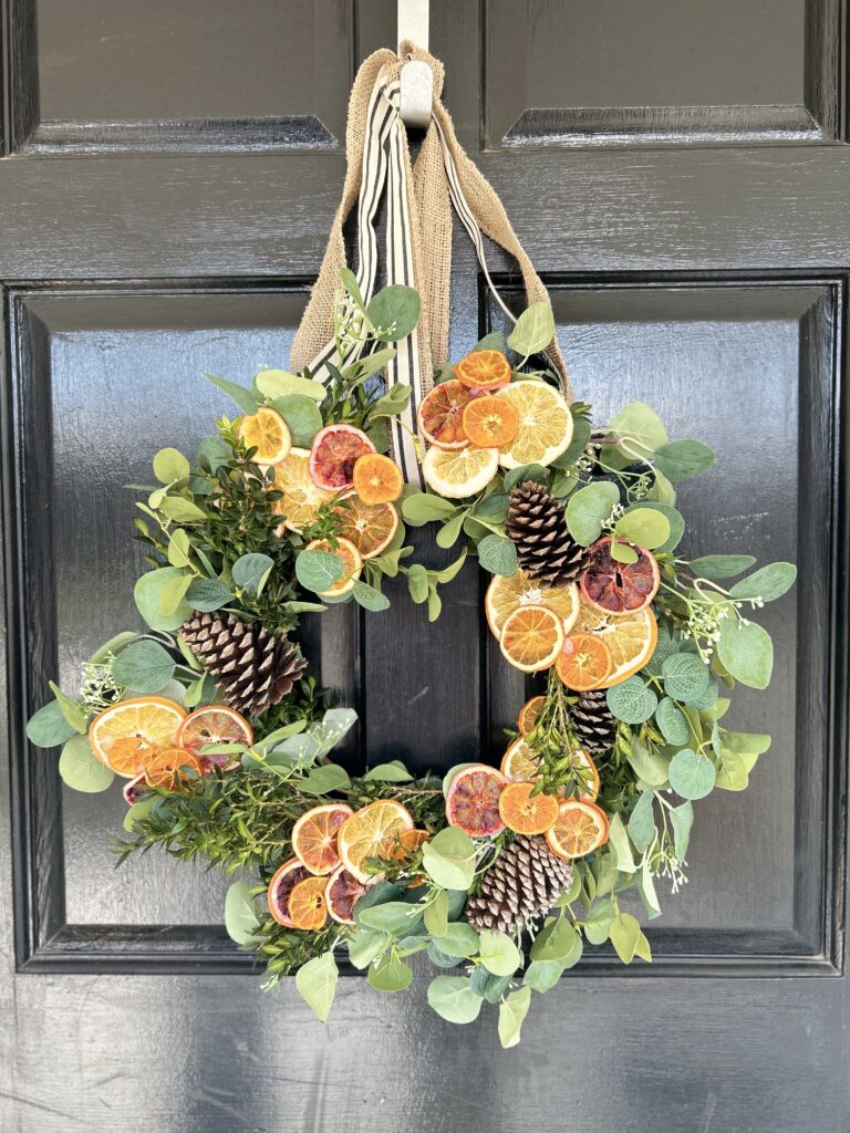 orange & eucalyptus winter wreath on a black door