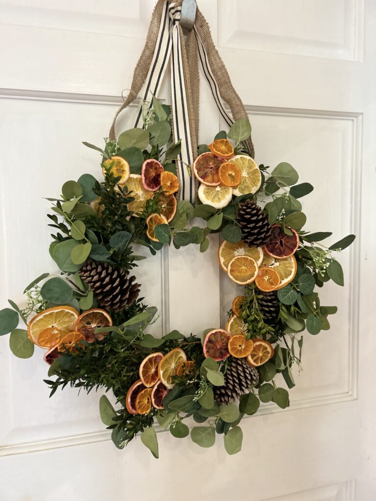orange & eucalyptus winter wreath on a white door