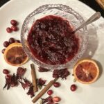 cranberry hibiscus sauce plated with spices and oranges