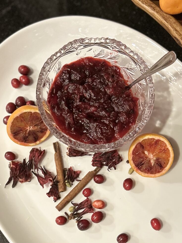 cranberry hibiscus sauce plated with spices and oranges