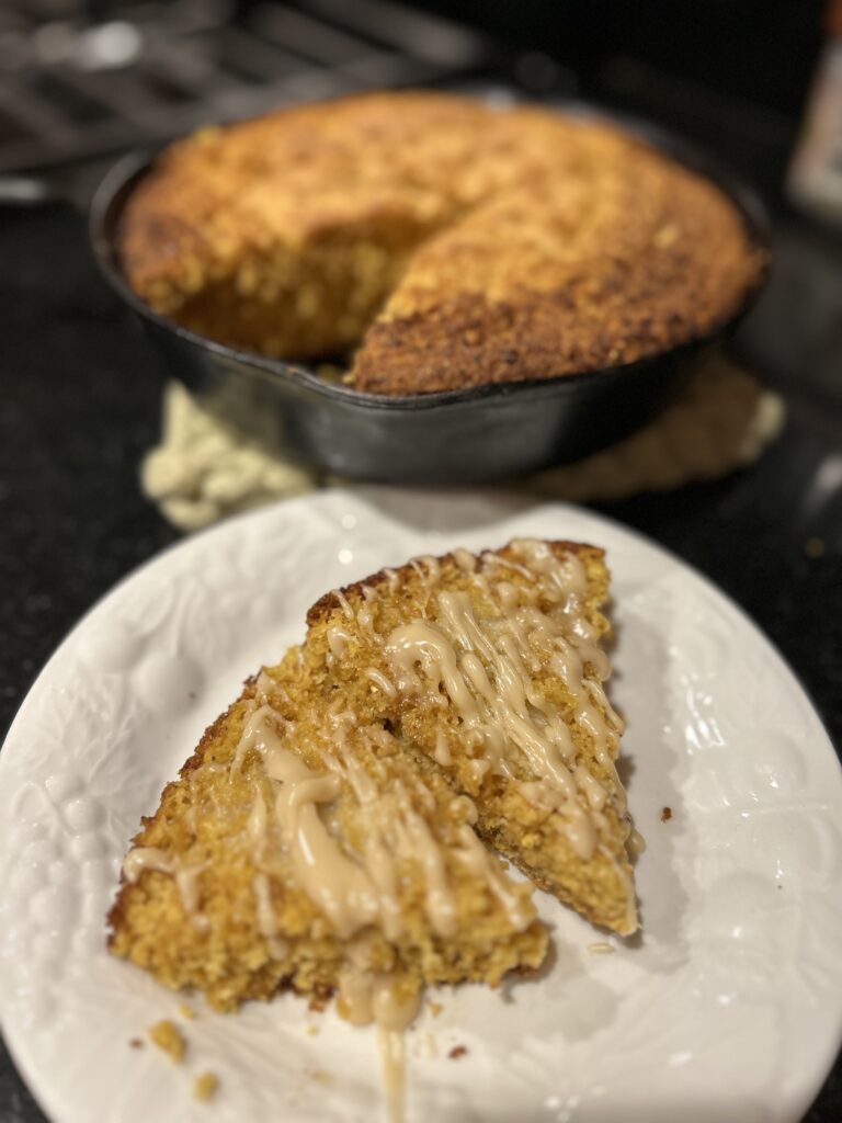 skillet of cornbread with a buttered slice on the side