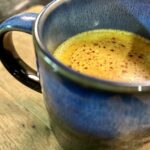 a blue mug of golden milk up close